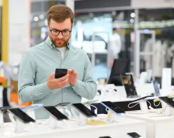 Happy,Man,Chooses,Mobile,Phone,In,Electronics,Store.